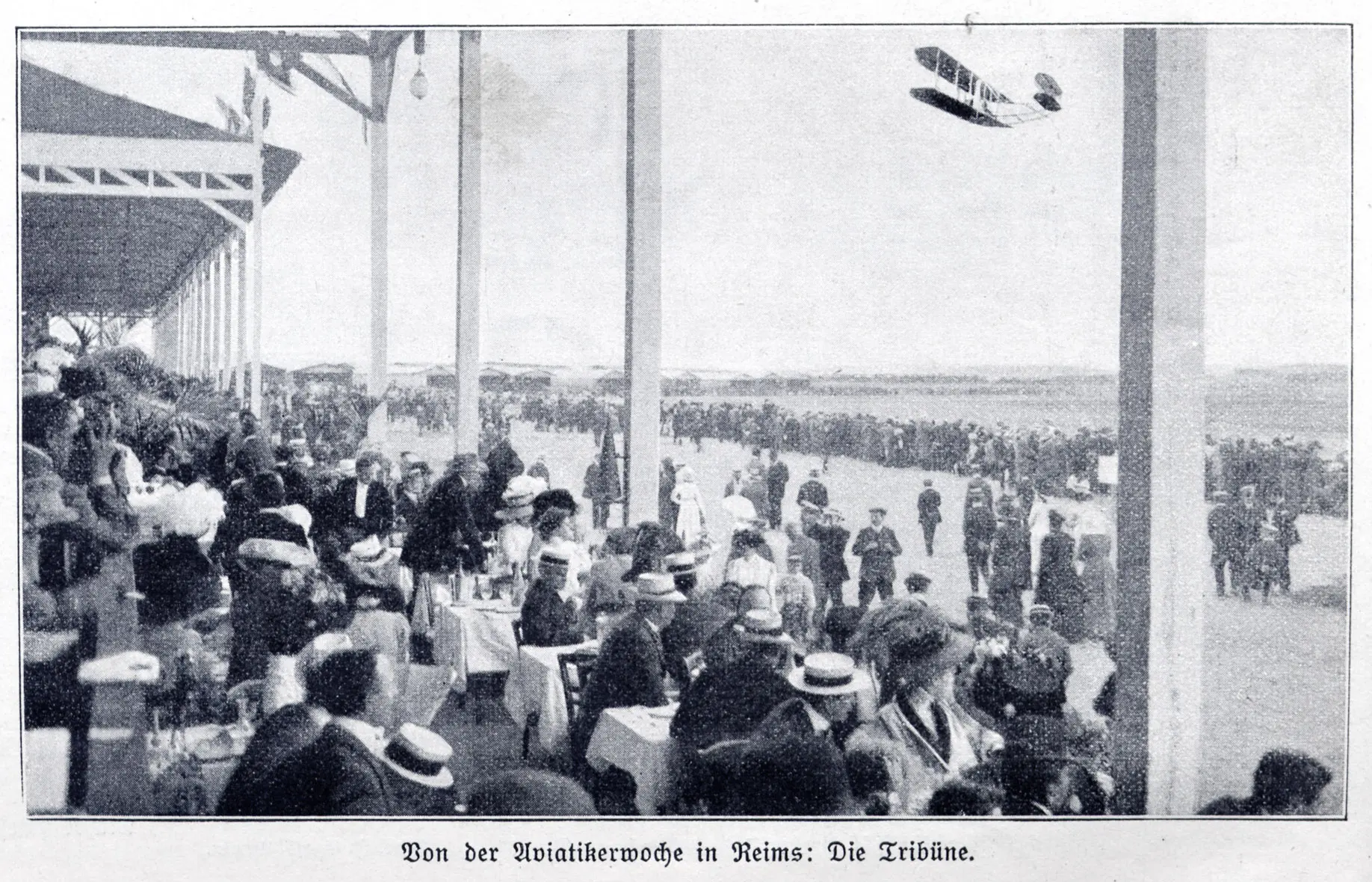 Photograph (taken from a catholic german magazin from 1910) of a biplane flying past the tribune of the Aviation week in Reims, France, August 22 - 29, 1909.
